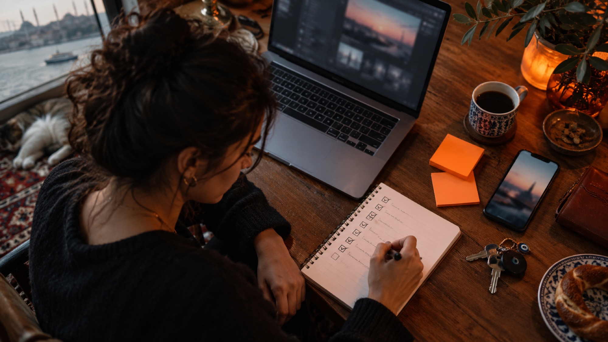 Laptop, a ticked checklist and a phone on a desk